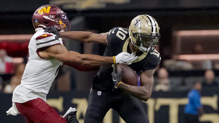 Dec 15, 2024; New Orleans, Louisiana, USA; New Orleans Saints wide receiver Marquez Valdes-Scantling (10) makes a reception against Washington Commanders safety Jeremy Chinn (11) during the second half both were slow getting up after the play after colliding with Washington Commanders safety Darrick Forrest (22) at Caesars Superdome. Mandatory Credit: Matthew Hinton-Imagn Images