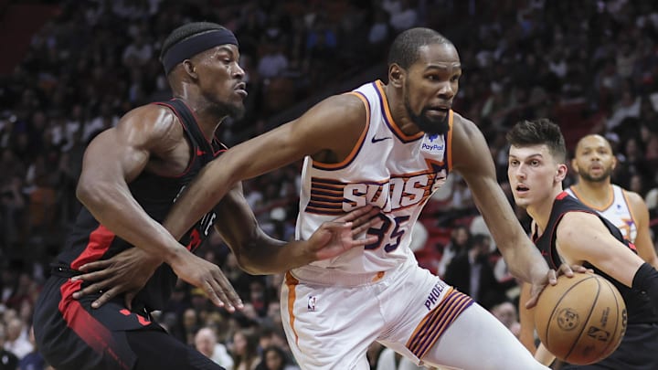 Jan 29, 2024; Miami, Florida, USA; Phoenix Suns forward Kevin Durant (35) moves to the basket past Miami Heat forward Jimmy Butler (22) and guard Tyler Herro (14) during the second quarter at Kaseya Center. Mandatory Credit: Sam Navarro-Imagn Images