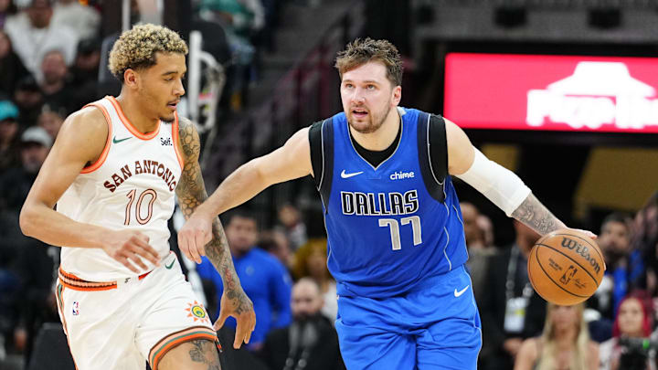 Mar 19, 2024; San Antonio, Texas, USA;  Dallas Mavericks guard Luka Doncic (77) dribbles past San Antonio Spurs forward Jeremy Sochan (10) in the second half at Frost Bank Center. Mandatory Credit: Daniel Dunn-Imagn Images