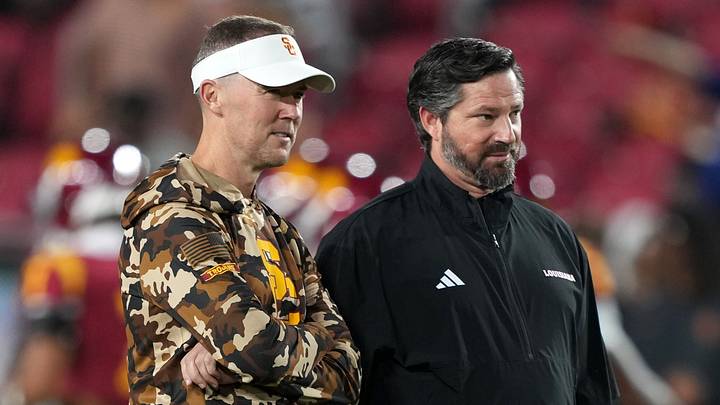 Sep 12, 2026; Los Angeles, California, USA; Southern California Trojans head coach Lincoln Riley (left) talks with Louisiana Ragin' Cajuns head coach Michael Desormeaux before the game at United Airlines Field at Los Angeles Memorial Coliseum. Mandatory Credit: Kirby Lee-Imagn Images