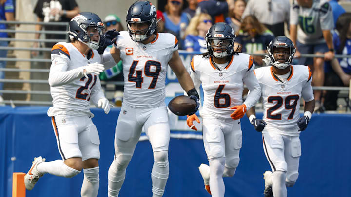 Sep 8, 2024; Seattle, Washington, USA; Denver Broncos linebacker Alex Singleton (49) celebrates with cornerback Riley Moss (21), safety P.J. Locke (6) and cornerback Ja'Quan McMillian (29) after intercepting a pass against the Seattle Seahawks during the first quarter at Lumen Field. 