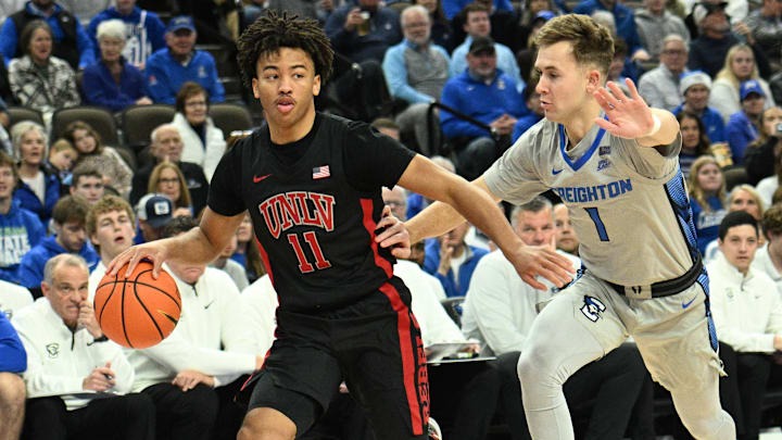 Dec 7, 2024; Omaha, Nebraska, USA;  UNLV Rebels guard Dedan Thomas Jr. (11) dribbles against Creighton Bluejays guard Steven Ashworth (1) in the first half at CHI Health Center Omaha. Mandatory Credit: Steven Branscombe-Imagn Images