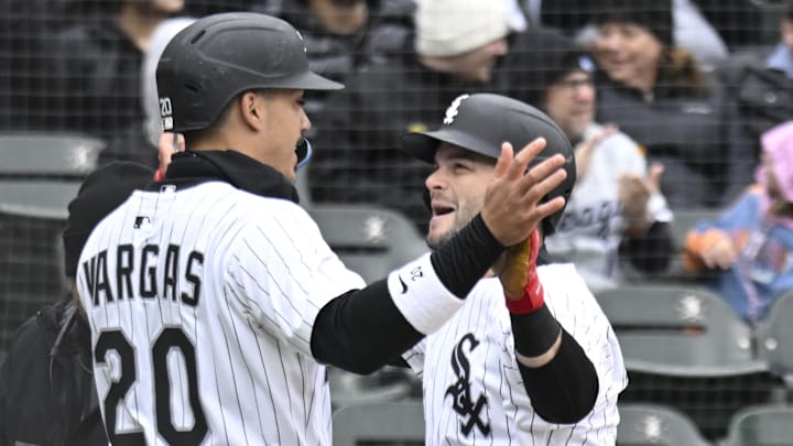 Chicago White Sox outfielder Andrew Benintendi (23) high fives   third baseman Miguel Vargas (20)  after hitting a three run home run during the second inning against the Minnesota Twins at Guaranteed Rate Field.