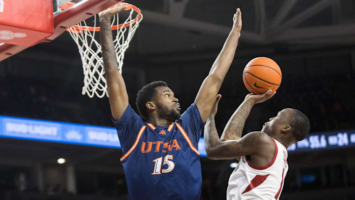 Arkansas guard Johnell "Nelly' Davis shoots while avoid the outstretched arm of Texas-San Antonio Roadrunners forward Jonnivius Smith (15) during the second half at Bud Walton Arena Tuesday. Davis scored 11 second-half points as the Razorbacks outscored UTSA 48-28 after intermission.