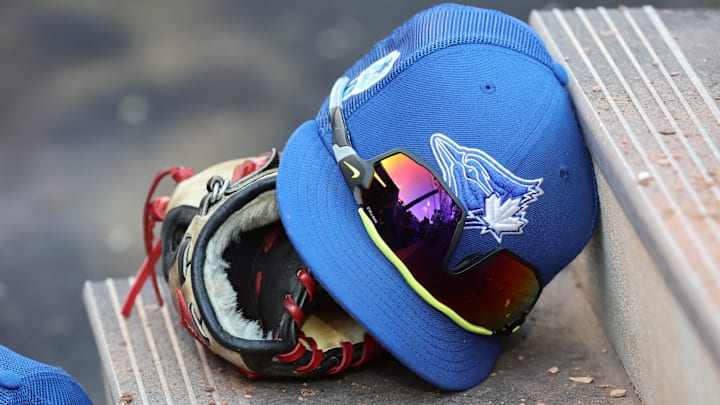 Mar 25, 2023; Dunedin, Florida, USA; A detail view of Toronto Blue Jays hat and glove against the Detroit Tigers at TD Ballpark. Mar 25, 2023; Dunedin, Florida, USA; A detail view of Toronto Blue Jays hat and glove against the Detroit Tigers at TD Ballpark.
