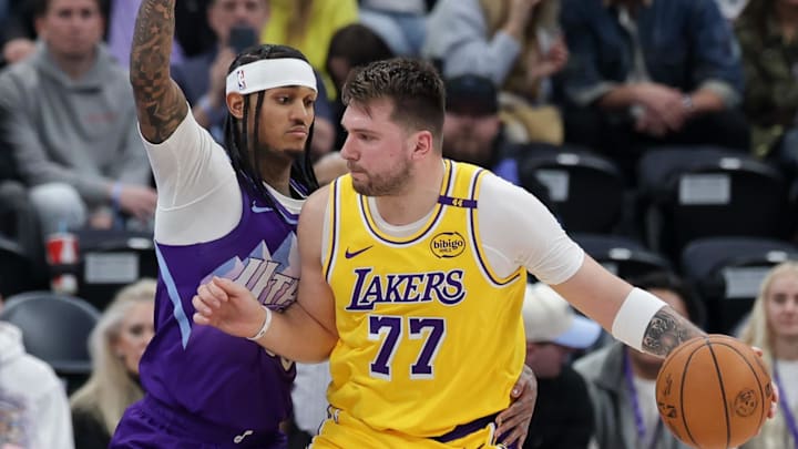 Feb 12, 2025; Salt Lake City, Utah, USA;  Los Angeles Lakers guard Luka Doncic (77) dribbles against Utah Jazz guard Jordan Clarkson (00) during the second half at Delta Center. Mandatory Credit: Chris Nicoll-Imagn Images