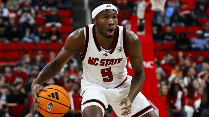 Dec 6, 2025; Raleigh, North Carolina, USA; NC State Wolfpack guard Tre Holloman (5) dribbles with the ball guarded by Liberty Flames guard Colin Porter (0) during the first half of the game at Lenovo Center. Mandatory Credit: Jaylynn Nash-Imagn Images Dec 6, 2025; Raleigh, North Carolina, USA; NC State Wolfpack guard Tre Holloman (5) dribbles with the ball guarded by Liberty Flames guard Colin Porter (0) during the first half of the game at Lenovo Center. Mandatory Credit: Jaylynn Nash-Imagn Images