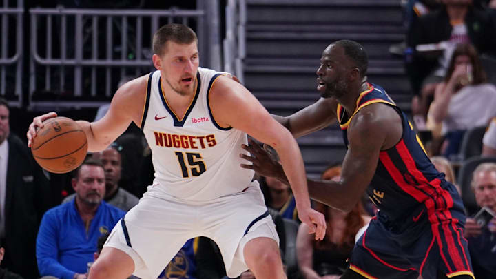Apr 4, 2025; San Francisco, California, USA;  Denver Nuggets center Nikola Jokic (15) is guarded by Golden State Warriors forward Draymond Green (23) in the third period at Chase Center. Mandatory Credit: David Gonzales-Imagn Images