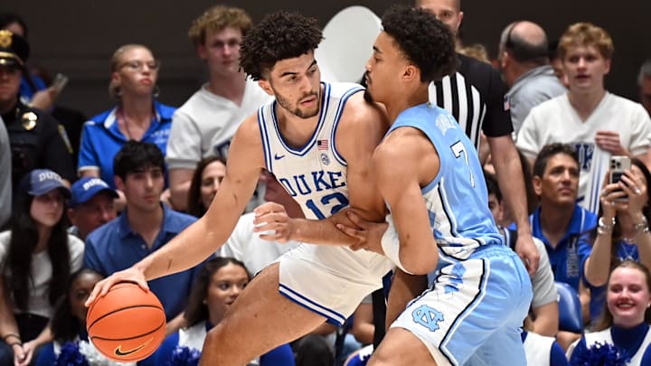 Mar 7, 2026; Durham, North Carolina, USA; Duke Blue Devils forward Cameron Boozer (12) controls the ball in front of North Carolina Tar Heels guard Seth Trimble (7) during the first half at Cameron Indoor Stadium. Mandatory Credit: Rob Kinnan-Imagn Images