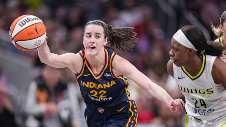 Indiana Fever guard Caitlin Clark (22) reaches for the ball during a game against the Dallas Wings at Gainbridge Fieldhouse in Indianapolis.