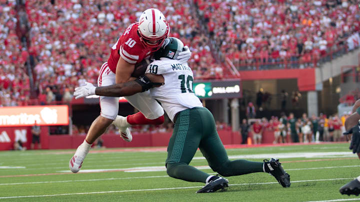 Oct 4, 2025; Lincoln, Nebraska, USA; Michigan State Spartans linebacker Wayne Matthews III (white) tackles Nebraska Cornhuskers tight end Heinrich Haarberg (red) at Memorial Stadium.