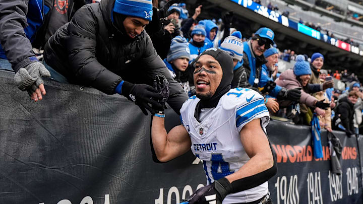 Detroit Lions wide receiver St. Brown high-fives fans celebrating the win over Chicago Bears as he exits the field at Soldier Field.