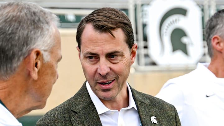Michigan State's Athletic Director J Batt, center, talks with former football coach Mark Dantonio before the football game against Western Michigan on Friday, Aug. 29, 2025, in East Lansing.