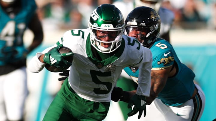 Dec 15, 2024; Jacksonville, Florida, USA; New York Jets wide receiver Garrett Wilson (5) runs with the ball chased by Jacksonville Jaguars safety Andre Cisco (5) in the fourth quarter at EverBank Stadium. Mandatory Credit: Nathan Ray Seebeck-Imagn Images