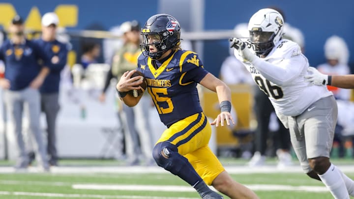 Nov 8, 2025; Morgantown, West Virginia, USA; West Virginia Mountaineers quarterback Scotty Fox Jr. (15) runs out of the pocket during the second quarter against the Colorado Buffaloes at Milan Puskar Stadium. Mandatory Credit: Ben Queen-Imagn Images