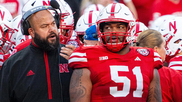 Nebraska offensive line coach Donovan Raiola talks with Justin Evans during the 2024 season.