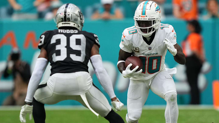 Nov 19, 2023; Miami Gardens, Florida, USA; Miami Dolphins wide receiver Tyreek Hill (10) runs with the ball against Las Vegas Raiders cornerback Nate Hobbs (39) during the second half at Hard Rock Stadium. Mandatory Credit: Jasen Vinlove-Imagn Images