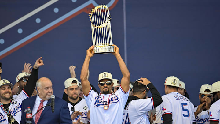 Texas Rangers second baseman Marcus Semien (2) raises the trophy during the celebration outside of the ballpark after the World Series championship parade at Globe Life Field.
