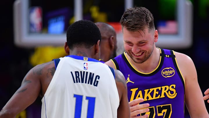 Feb 25, 2025; Los Angeles, California, USA; Los Angeles Lakers guard Luka Doncic (77) reacts with Dallas Mavericks guard Kyrie Irving (11) during the first quarter at Crypto.com Arena. Mandatory Credit: Gary A. Vasquez-Imagn Images