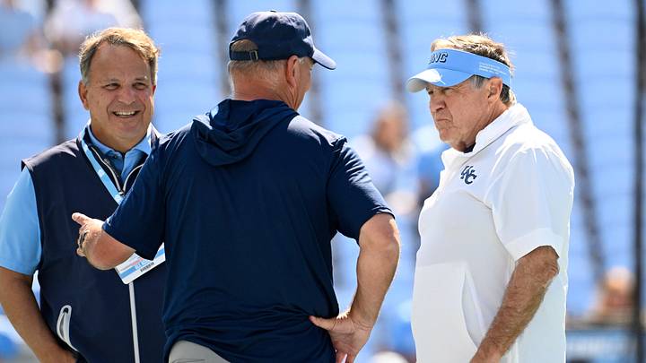 Sep 13, 2025; Chapel Hill, North Carolina, USA; Richmond Spiders head coach Russ Huesman talks to North Carolina Tar Heels general manger Michael Lombardi and head coach Bill Belichick before the game at Kenan Stadium. Mandatory Credit: Bob Donnan-Imagn Images Sep 13, 2025; Chapel Hill, North Carolina, USA; Richmond Spiders head coach Russ Huesman talks to North Carolina Tar Heels general manger Michael Lombardi and head coach Bill Belichick before the game at Kenan Stadium. Mandatory Credit: Bob Donnan-Imagn Images