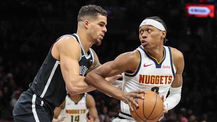 Jan 4, 2026; Brooklyn, New York, USA;  Denver Nuggets guard Peyton Watson (8) looks to drive past Brooklyn Nets forward Michael Porter Jr. (17) in the first quarter at Barclays Center.