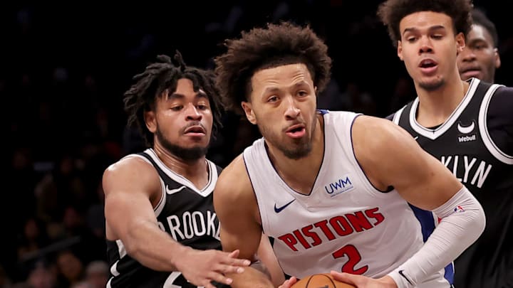 Dec 23, 2023; Brooklyn, New York, USA; Detroit Pistons guard Cade Cunningham (2) drives to the basket against Brooklyn Nets guard Cam Thomas (24) and forward Cameron Johnson (2) during the fourth quarter at Barclays Center. Mandatory Credit: Brad Penner-Imagn Images