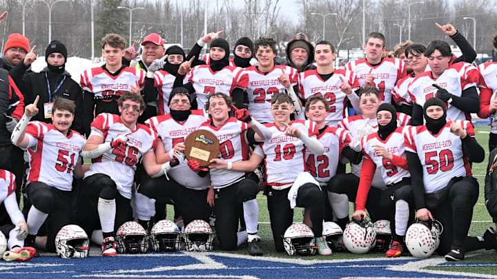 The Morrisville-Eaton Mavericks pose with their championship plaque after beating the Eldred Yellowjackets 40-12 in New York's state regional eight-player football championship game at Cicero-North Syracuse High School's Michael J. Bragman Athletic Complex Sunday, Nov. 30, 2025, in Cicero, New York.