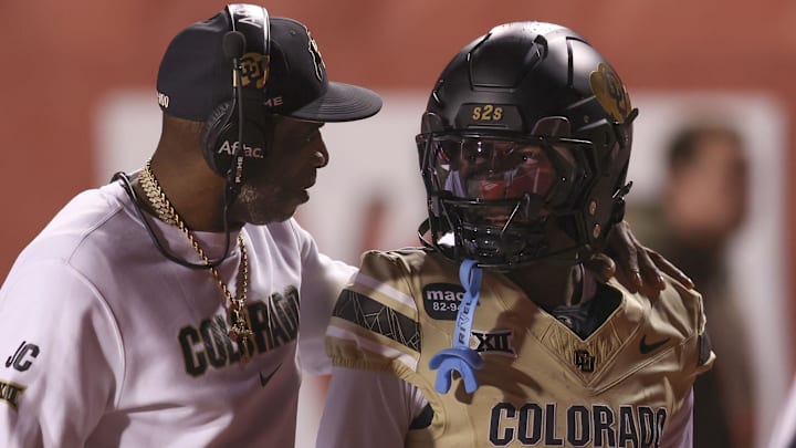 Oct 25, 2025; Salt Lake City, Utah, USA; Colorado Buffaloes head coach Deion Sanders speaks with Colorado Buffaloes wide receiver Isaiah Hardge (17) before the game against the Utah Utes at Rice-Eccles Stadium. Mandatory Credit: Rob Gray-Imagn Images