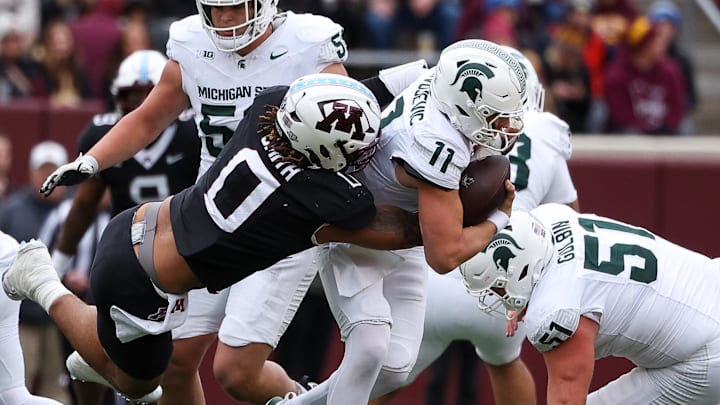 Nov 1, 2025; Minneapolis, Minnesota, USA; Minnesota Golden Gophers defensive lineman Anthony Smith (0) tackles Michigan State Spartans quarterback Alessio Milivojevic (11) during the first half at Huntington Bank Stadium. Mandatory Credit: Matt Krohn-Imagn Images Nov 1, 2025; Minneapolis, Minnesota, USA; Minnesota Golden Gophers defensive lineman Anthony Smith (0) tackles Michigan State Spartans quarterback Alessio Milivojevic (11) during the first half at Huntington Bank Stadium. Mandatory Credit: Matt Krohn-Imagn Images