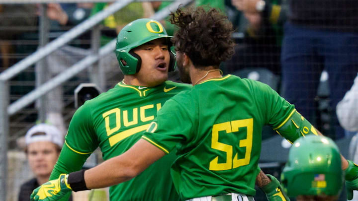 Oregon outfielder Angel Laya, center, and Oregon infielder Naulivou Lauaki Jr., left, celebrate a home run by Laya as the Oregon Ducks host the Oregon State Beavers on March 3, 2026, at PK Park in Eugene, Oregon.