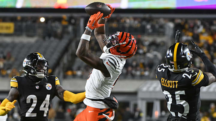 Jan 4, 2025; Pittsburgh, Pennsylvania, USA; Cincinnati Bengals wide receiver Tee Higgins (5) catches a pass in front of Pittsburgh Steelers cornerback Joey Porter Jr. (24) and safety DeShon Elliott (25) during the second quarter at Acrisure Stadium. Mandatory Credit: Barry Reeger-Imagn Images