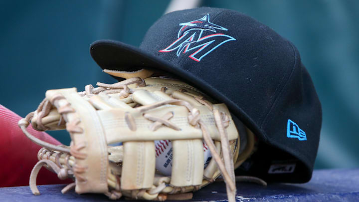 Apr 24, 2024; Atlanta, Georgia, USA; A detailed view of a Miami Marlins hat and glove in the dugout before a game against the Atlanta Braves at Truist Park. Mandatory Credit: Brett Davis-Imagn Images