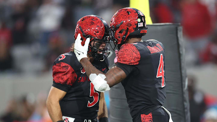 Oct 5, 2024; San Diego, California, USA; San Diego State Aztecs wide receiver Louis Brown IV (4) celebrates a touchdown with quarterback Danny O'Neil (5) during the second quarter against the Hawaii Rainbow Warriors at Snapdragon Stadium. Mandatory Credit: Abe Arredondo-Imagn Images