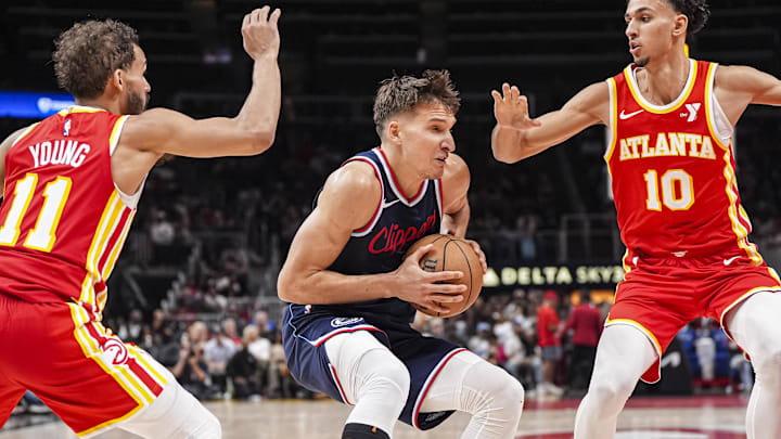 Mar 14, 2025; Atlanta, Georgia, USA; LA Clippers guard Bogdan Bogdanovic (10) handles the ball between Atlanta Hawks guard Trae Young (11) and forward Zaccharie Risacher (10) during the second half at State Farm Arena. Mandatory Credit: Dale Zanine-Imagn Images