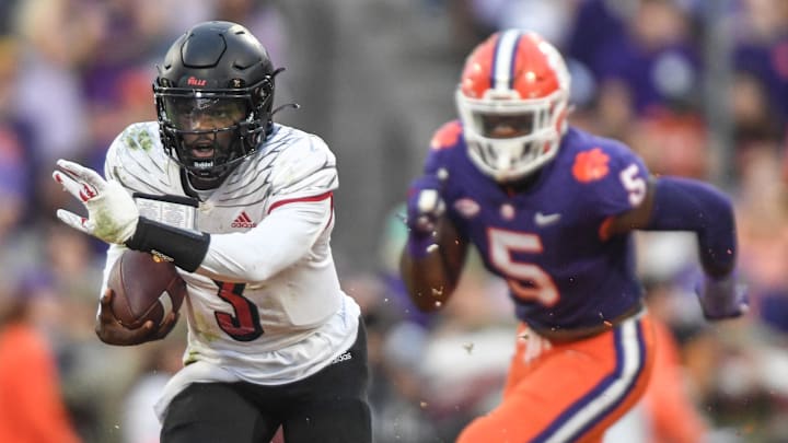Nov 12, 2022; Clemson, South Carolina, USA; Louisville quarterback Malik Cunningham (3) runs by Clemson defensive end K.J. Henry (5)  during the second quarter at Memorial Stadium in Clemson, South Carolina Saturday, Nov. 12, 2022. 