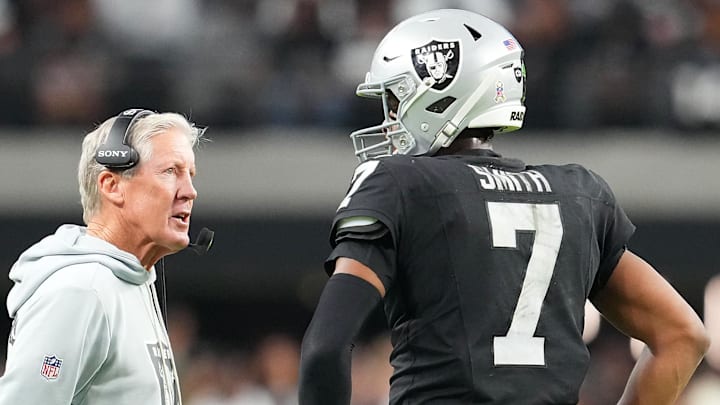Nov 23, 2025; Paradise, Nevada, USA; Las Vegas Raiders quarterback Geno Smith (7) talks to head coach Pete Carroll in game against the Cleveland Browns during the fourth quarter at Allegiant Stadium. Mandatory Credit: Stephen R. Sylvanie-Imagn Images