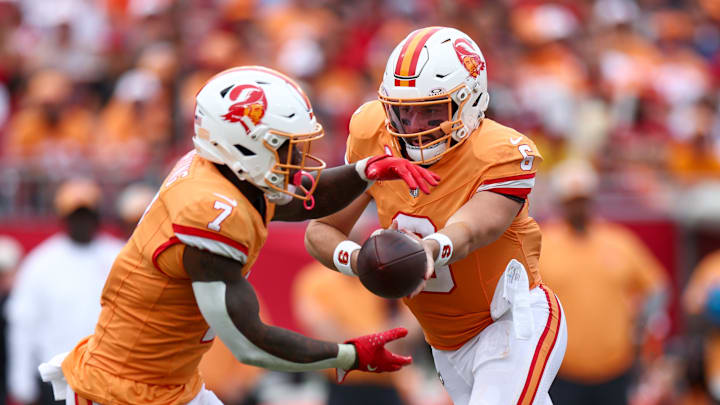 Oct 27, 2024; Tampa, Florida, USA; Tampa Bay Buccaneers quarterback Baker Mayfield (6) hands off to running back Bucky Irving (7) against the Atlanta Falcons in the third quarter at Raymond James Stadium. Mandatory Credit: Nathan Ray Seebeck-Imagn Images