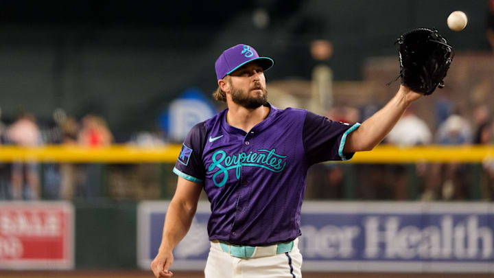 Aug 8, 2025; Phoenix, Arizona, USA; Arizona Diamondbacks pitcher Kendall Graveman (49) reaches out to catch a ball while on the mound to pitch in the eighth inning against the Colorado Rockies at Chase Field. Mandatory Credit: Allan Henry-Imagn Images