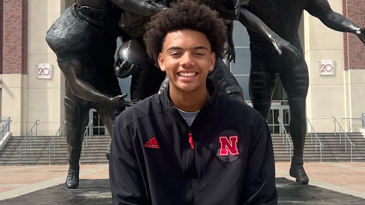 Trae Taylor in-front of a statue showcasing a national championship.