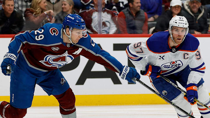 Jan 16, 2025; Denver, Colorado, USA; Colorado Avalanche center Nathan MacKinnon (29) knocks the puck away from Edmonton Oilers center Connor McDavid (97) in the first period at Ball Arena. Mandatory Credit: Isaiah J. Downing-Imagn Images
