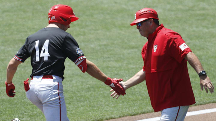 Jun 19, 2021; Omaha, Nebraska, USA;  NC State Wolfpack left fielder Jonny Butler (14) is congratulated by head coach Elliott Avent after hitting a home run against the Stanford Cardinal at TD Ameritrade Park. Mandatory Credit: Bruce Thorson-Imagn Images