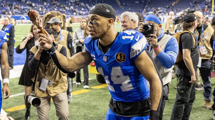 Detroit Lions wide receiver Amon-Ra St. Brown (14) tosses a turkey leg to a fan after the annual Thanksgiving Day Classic