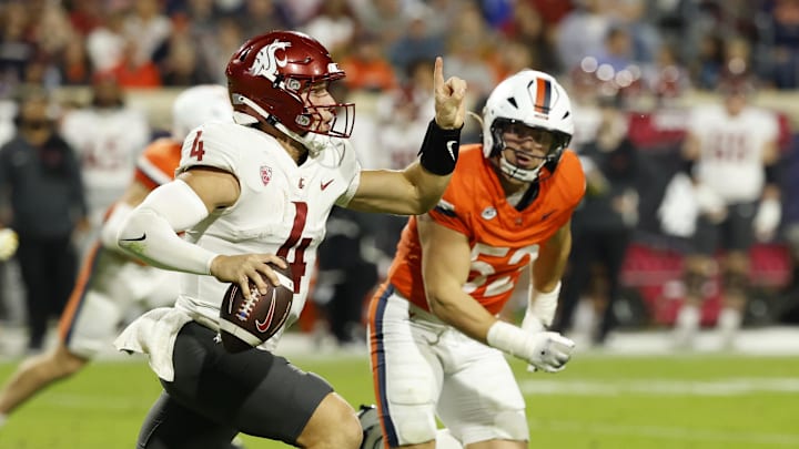 Oct 18, 2025; Charlottesville, Virginia, USA; Washington State Cougars quarterback Zevi Eckhaus (4) scrambles from Virginia Cavaliers defensive lineman Daniel Rickert (52) in the third quarter at Scott Stadium. Mandatory Credit: Geoff Burke-Imagn Images