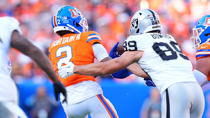 Oct 6, 2024; Denver, Colorado, USA; Denver Broncos cornerback Pat Surtain II (2) brings in an interception away from Las Vegas Raiders tight end Brock Bowers (89) in the fourth quarter at Empower Field at Mile High. 