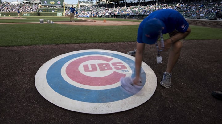 Jun 19, 2017; Chicago, IL, USA; A member of the grounds crew wipes off the Chicago Cubs' on deck logo prior to a game against the San Diego Padres at Wrigley Field. 