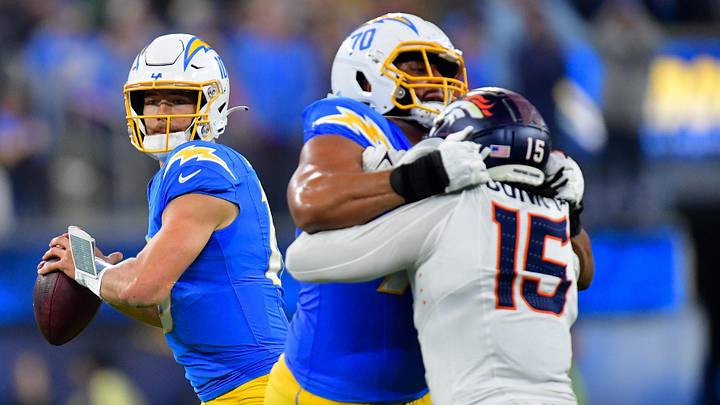 Dec 19, 2024; Inglewood, California, USA; Los Angeles Chargers quarterback Justin Herbert (10) drops back to pass as offensive tackle Rashawn Slater (70) provides coverage against Denver Broncos linebacker Nik Bonitto (15) during the second half at SoFi Stadium. Mandatory Credit: Gary A. Vasquez-Imagn Images Dec 19, 2024; Inglewood, California, USA; Los Angeles Chargers quarterback Justin Herbert (10) drops back to pass as offensive tackle Rashawn Slater (70) provides coverage against Denver Broncos linebacker Nik Bonitto (15) during the second half at SoFi Stadium. Mandatory Credit: Gary A. Vasquez-Imagn Images