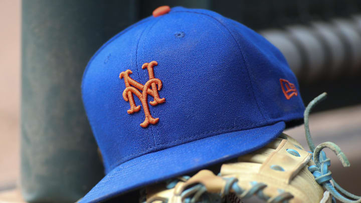 Jul 13, 2022; Atlanta, Georgia, USA; A detailed view of a New York Mets hat and glove in the dugout against the Atlanta Braves in the eighth inning at Truist Park. 