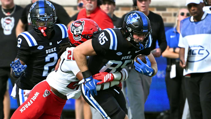 Sep 20, 2025; Durham, North Carolina, USA;  Duke Blue Devils tight end Jeremiah Hasley (85) is tackled by North Carolina State Wolfpack defensive back Asaad Brown Jr. (26) during the first quarter at Wallace Wade Stadium. Mandatory Credit: Zachary Taft-Imagn Images