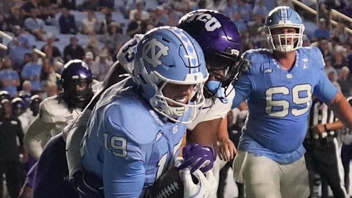 Sep 1, 2025; Chapel Hill, North Carolina, USA; North Carolina Tar Heels tight end Jake Johnson (19) scores a touchdown as TCU Horned Frogs linebacker Max Carroll (33) defends in the third quarter at Kenan Stadium. Sep 1, 2025; Chapel Hill, North Carolina, USA; North Carolina Tar Heels tight end Jake Johnson (19) scores a touchdown as TCU Horned Frogs linebacker Max Carroll (33) defends in the third quarter at Kenan Stadium.