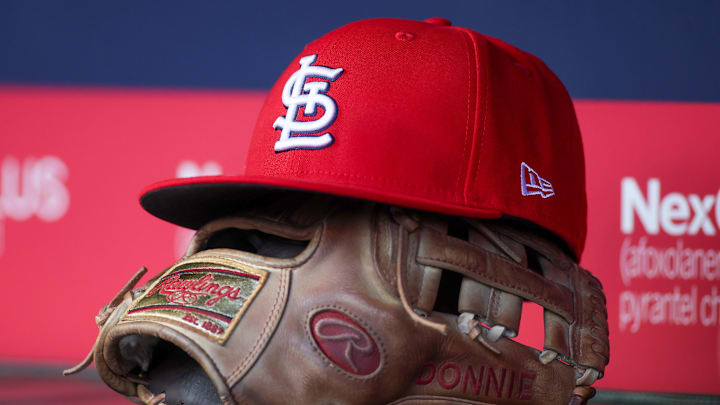 Apr 21, 2025; Atlanta, Georgia, USA; A St. Louis Cardinals hat and glove in the dugout against the Atlanta Braves in the first inning at Truist Park. 